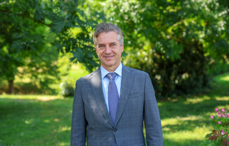 PV (The Prime Minister is standing and smiling in the middle of a green park, surrounded by trees and grass.)