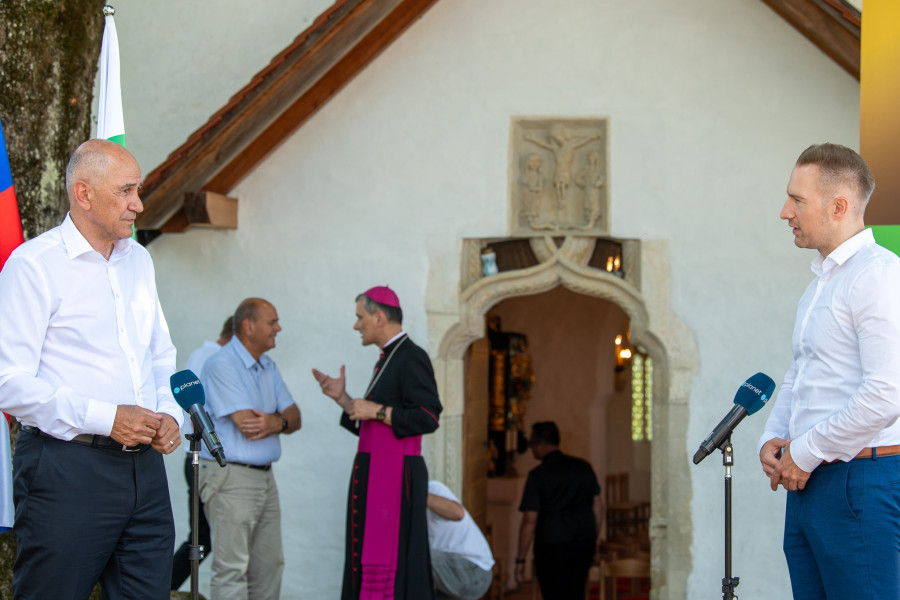two men in front of microphones in front of a church
