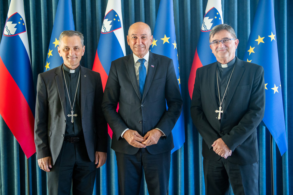 trije moški pred zastavami