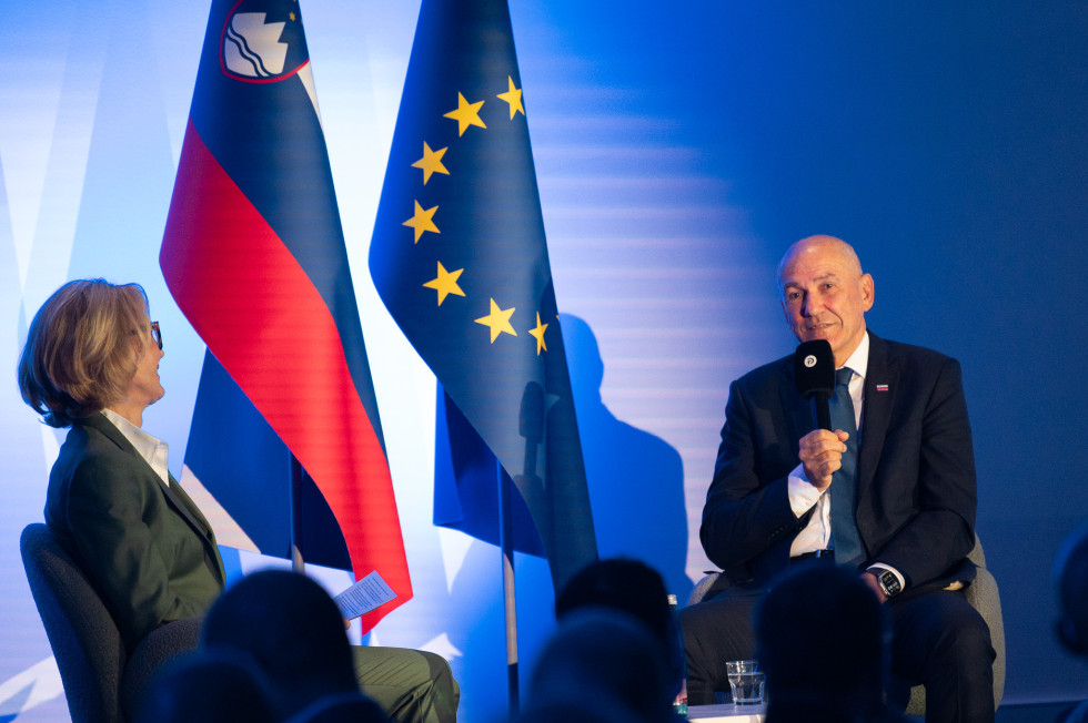 Predsednik vlade, v ozadju evropsk in slovenska zastava 