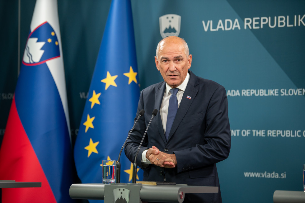 moški za mikrofoni, ko gleda v kamero in si mane dlani