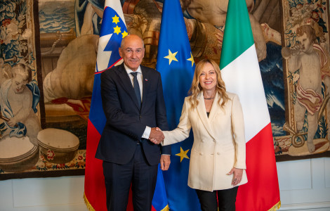 Srečanje PV Meloni 1 05102026 (Janez Janša and Giorgia Meloni are standing and shaking hands, with flags and a tapestry in the background.)