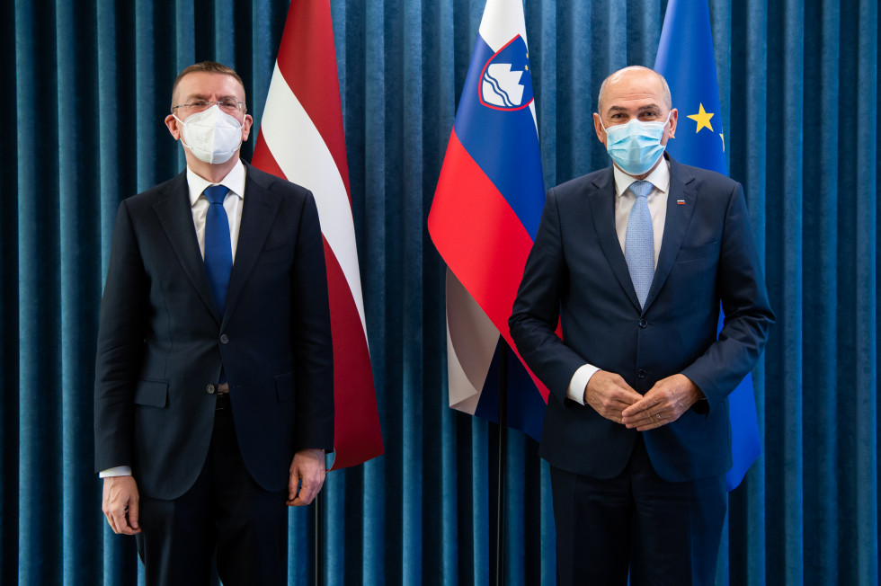 Edgars Rinkçvičs in Janez Janša, v ozadju zastave.