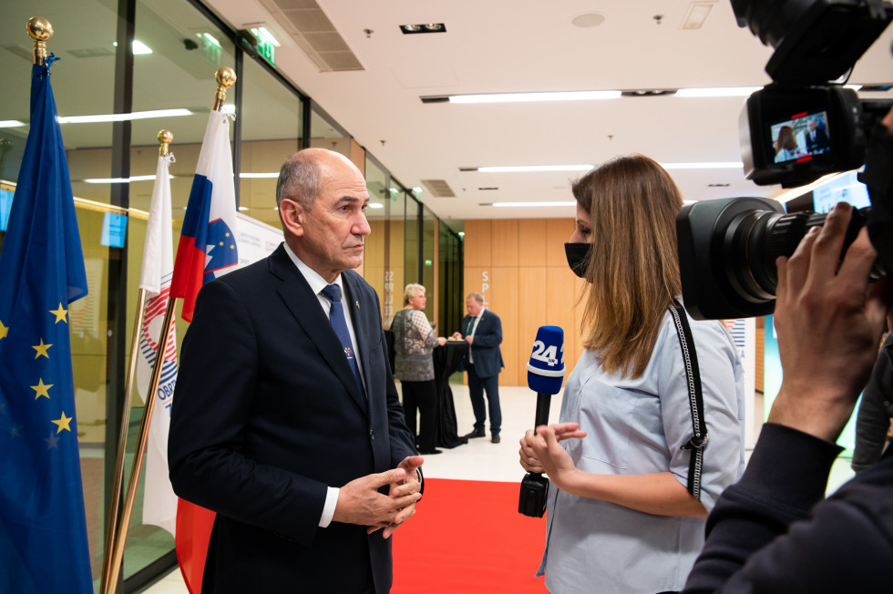 Predsednik vlade Janez Janša in novinarka med izjavo