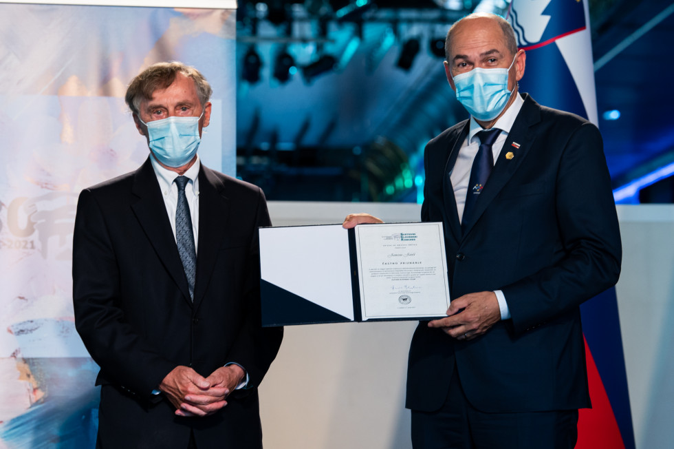 Dr. Boris Pleskovič, predsednik SSK in Janez Janša, ki v rokah drži priznanje