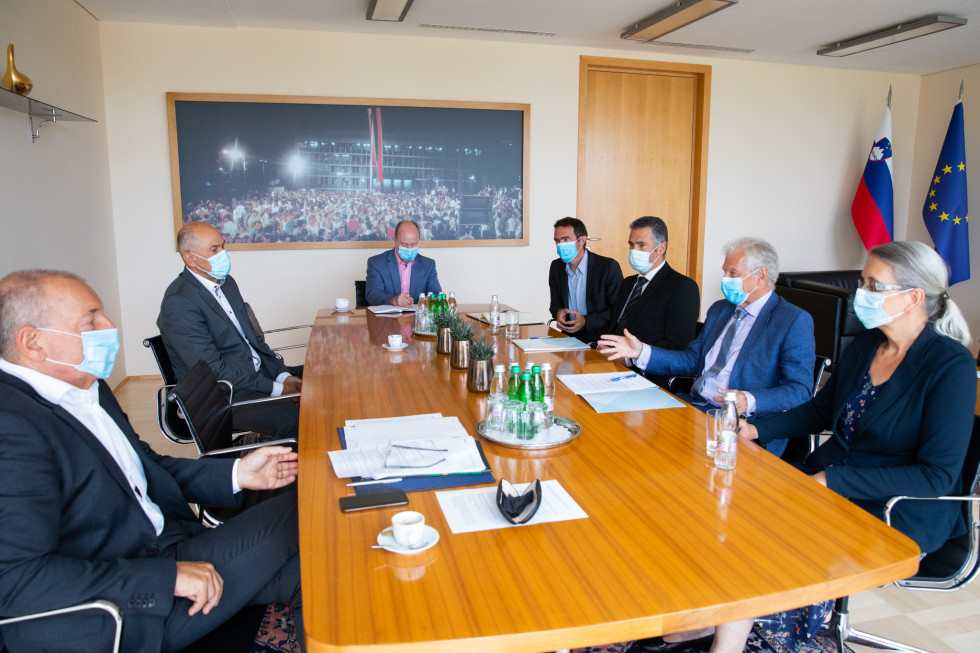Andrej Šircelj in Janez Janša na srečanju s s predsednikom in člani Fiskalnega sveta, sedijo za mizo.