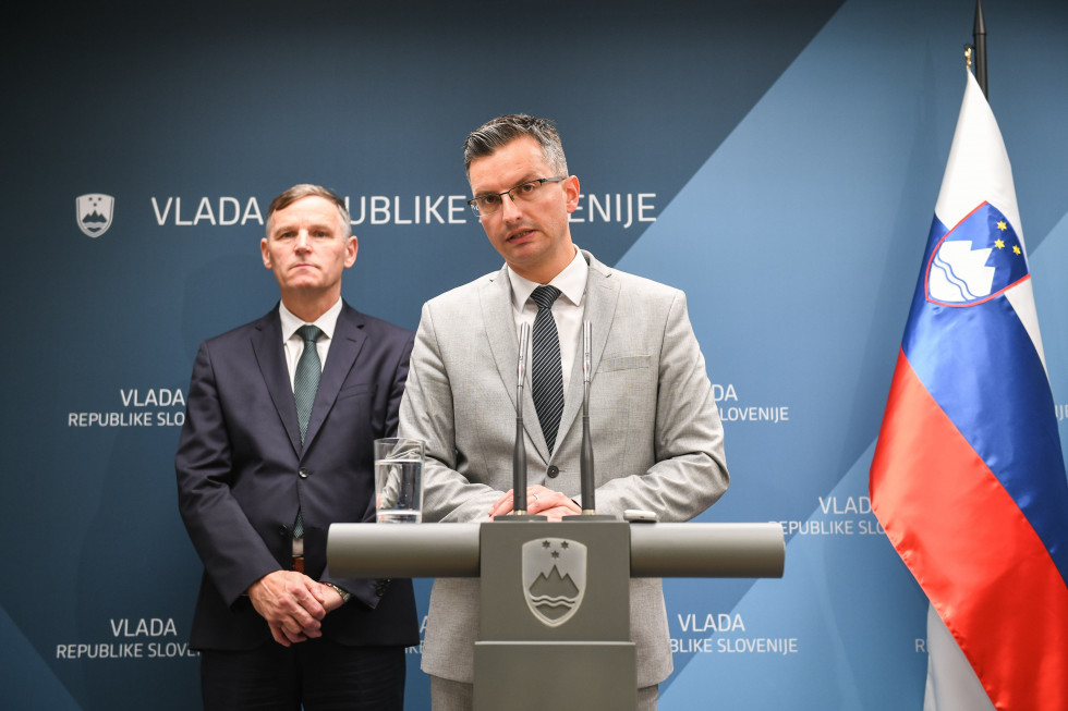 Za govorniškim pultom govori premier Marjan Šarec, za njim stoji finančni minister Andrej Bertoncelj.