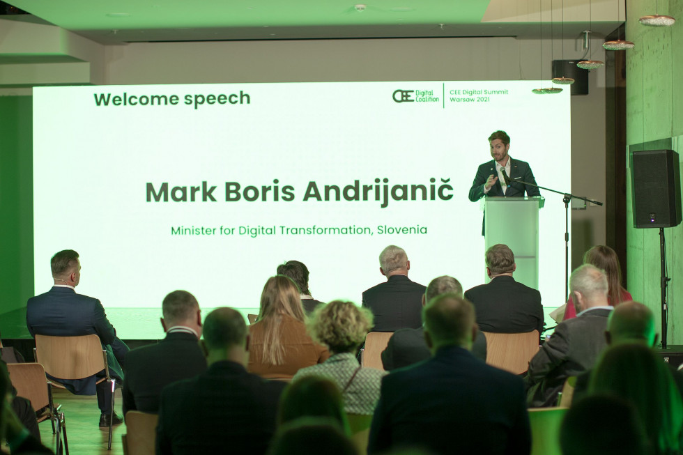 Minister Mark Boris Andrijanič za govornico, v ospredju poslušalci.