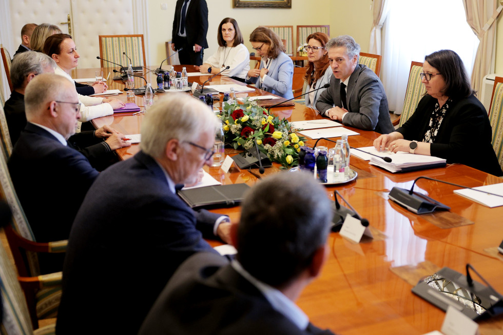 Predsednik vlade sedi za omizjem na sestanku s predstavniki pravosodja