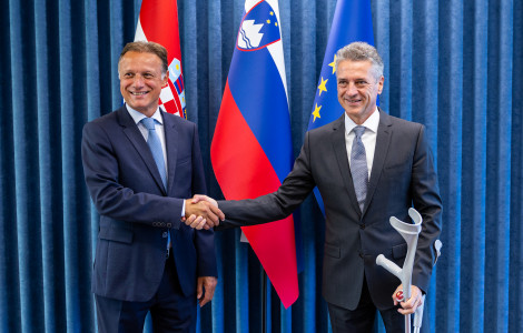 Jandrokovic3 (Prime Minister shakes hands with the President of the Croatian Parliament in front of the flags)