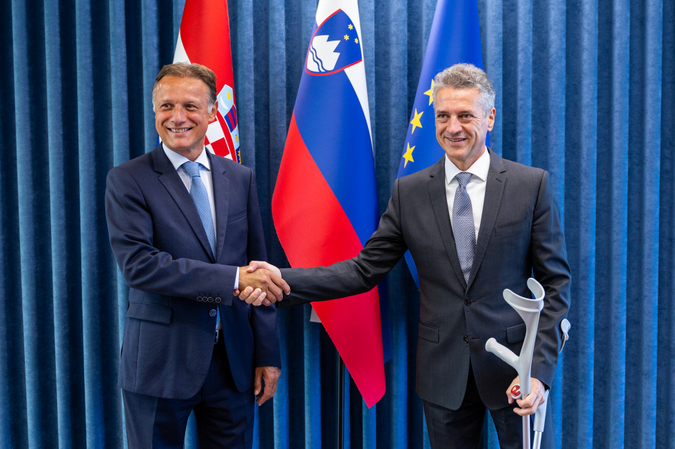 Prime Minister shakes hands with the President of the Croatian Parliament in front of the flags