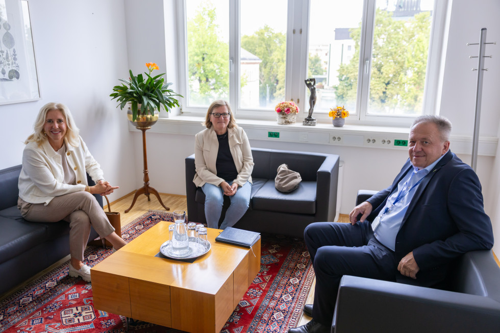 Tri osebe sedijo za mizo