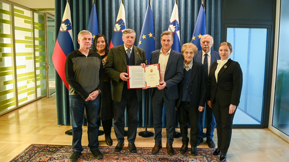 Predsednik vlade se stoje fotografira z delegacijo ZZB NOB