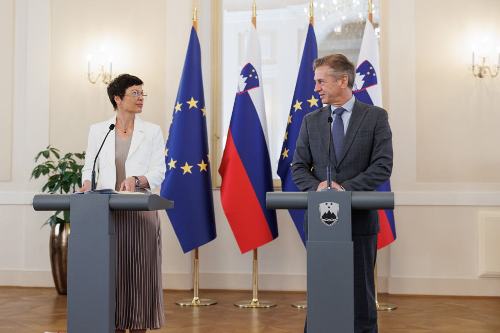 Predsednik vlade in komisarka Marta Kos stojita za govornico v Kristalni dvorani