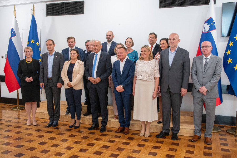 Predsednik vlade stoji s skupino predstavnikov Seje Sveta za Slovence po svetu in se fotografira