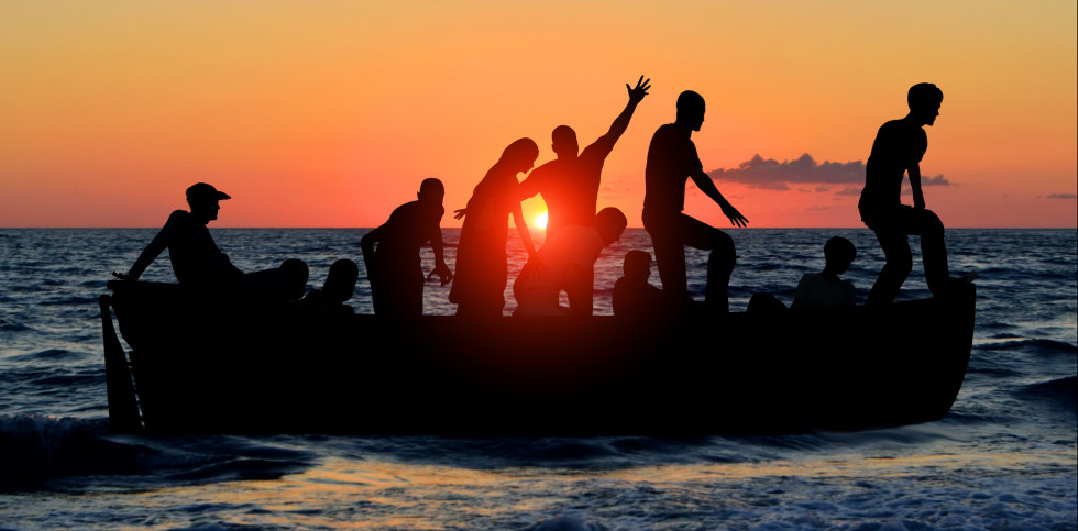A group of people standing on top of a boat in the ocean.