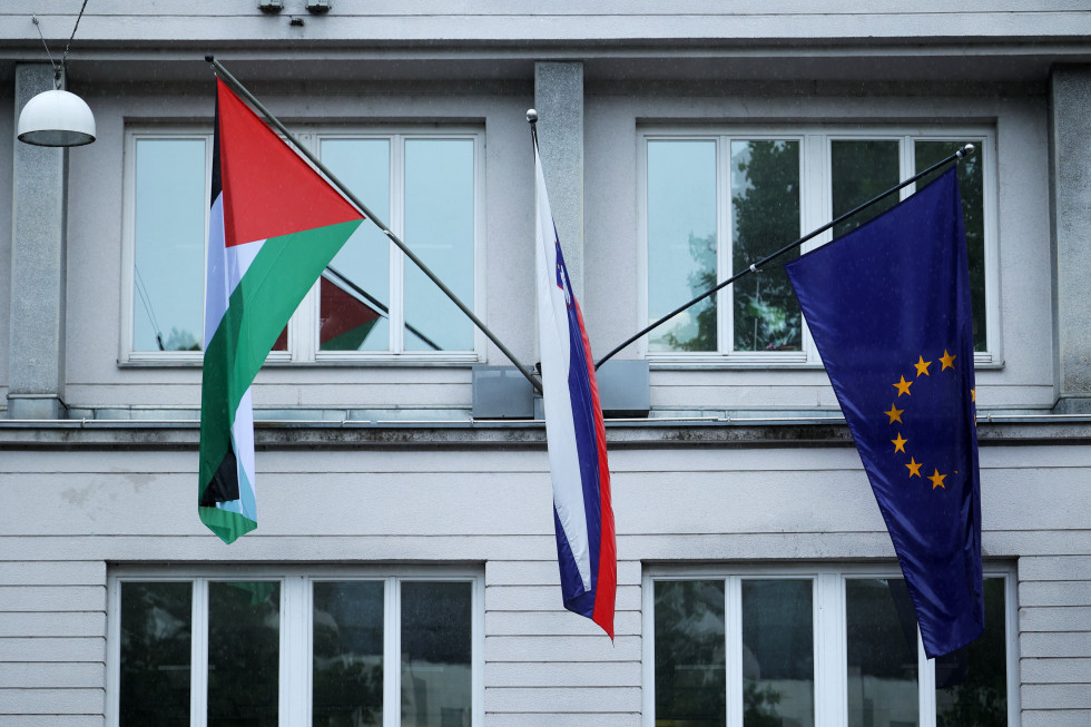Pred poslopjem vlade visijo tri zastave. Levo palestinska, v sredini slovenska in na desni evropska. 