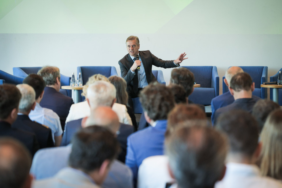 Predsednika vlade z mikrofonom v roku govori na konferenci