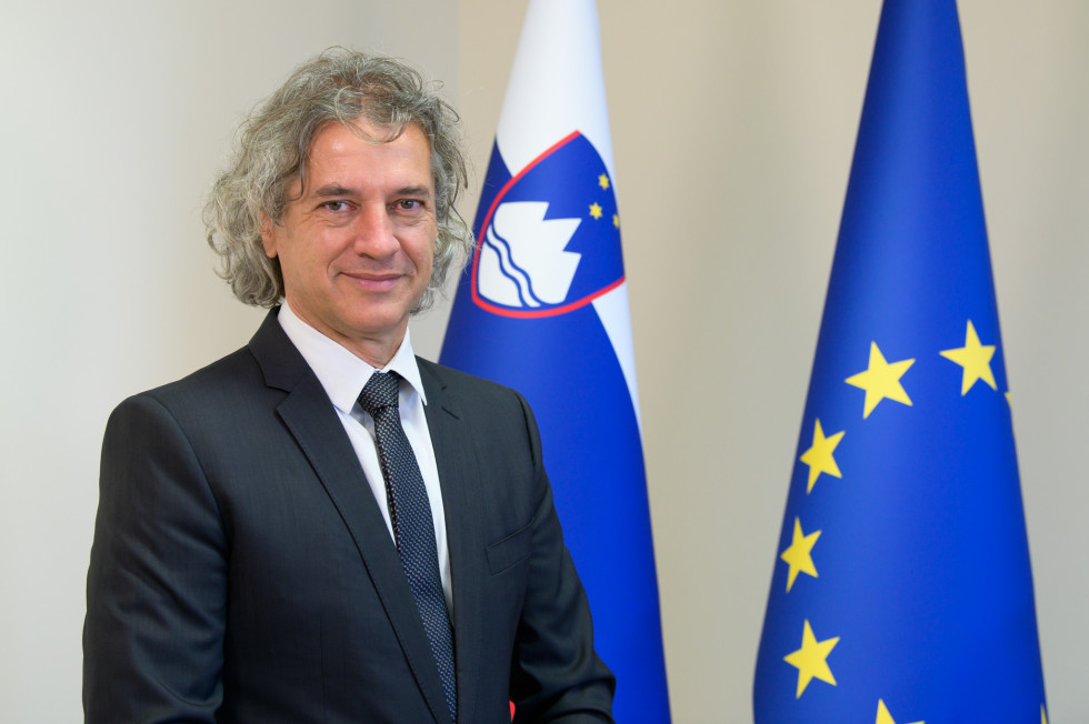 Prime Minister standing in front of the flags