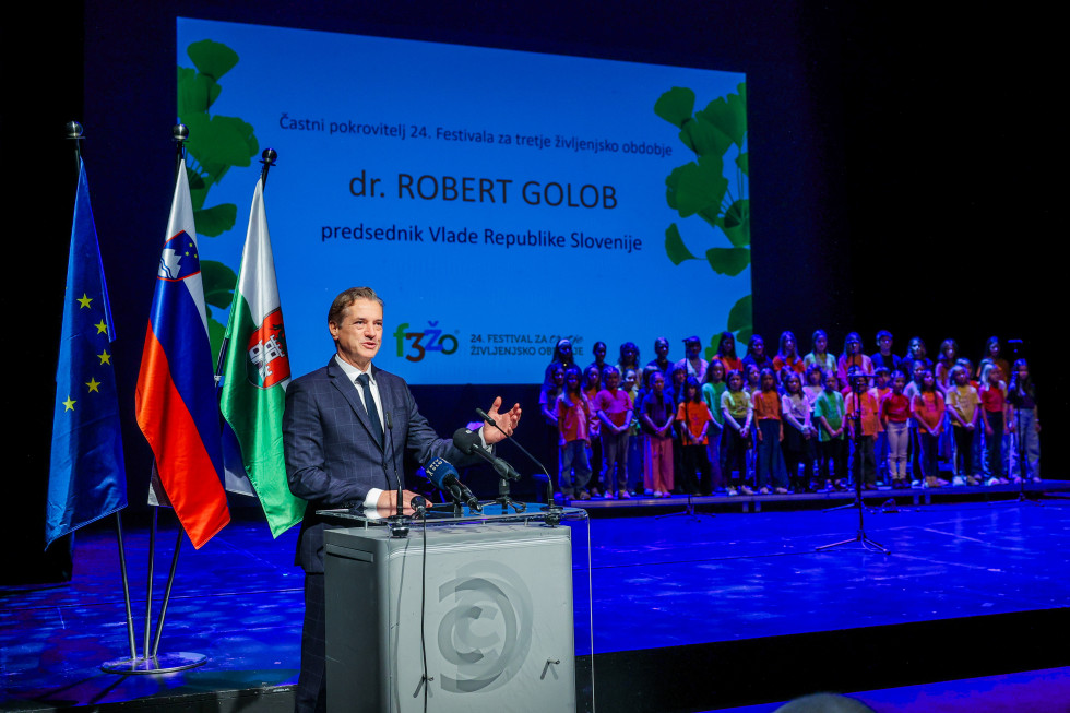 Premier Golob stoji za govorniškim pultom v nagovoru na festivalu