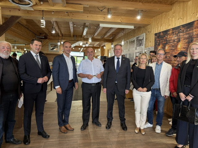 Moški in ženske stojijo pred fotografskim aparatom