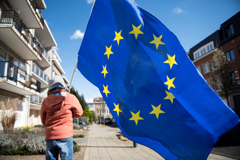 Deček nosi veliko zastavo Evropske unije
