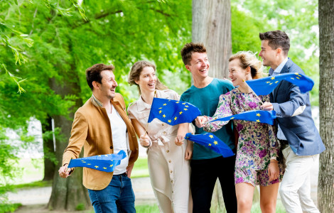 EC Audiovisual Service (A group of young boys and girls hold European flags in front of them.)