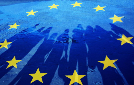 policies01 c istock kamisoka (Yellow stars in a circle on a blue background, on which the shadows of people are also visible.)