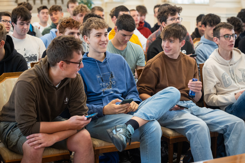 Nasmejani dijaki, ki v roki držijo mobilni telefon