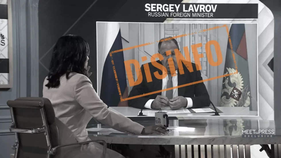 Posnetek televizijskega intervjuja, kjer je na zaslonu prikazan ruski zunanji minister Sergej Lavrov; čez zaslon je velik oranžen napis »DISINFO«.