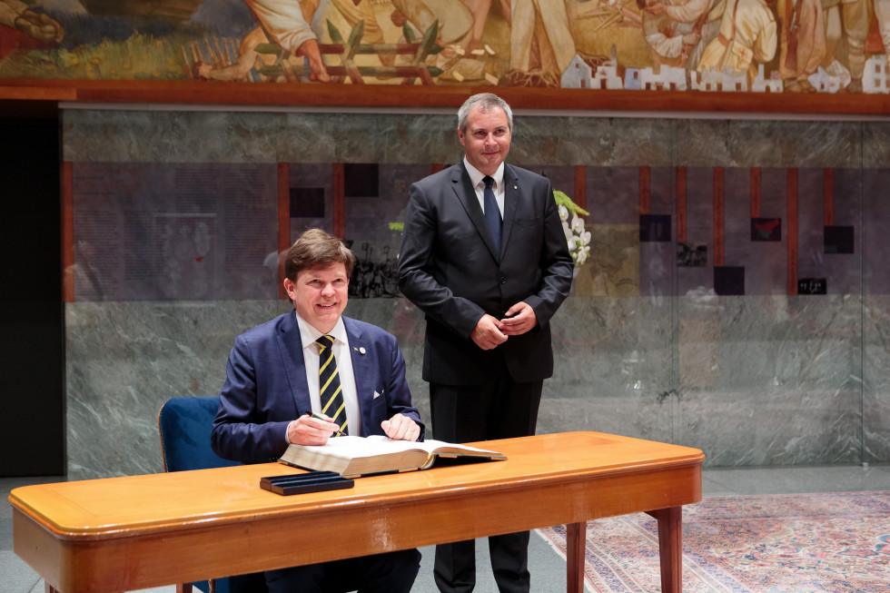 vpisovanje predsednika švedskega parlamenta v knjigo gostov, za njim stoji predsednik slovenskega državnega zbora v preddverju velike dvorane državnega zbora