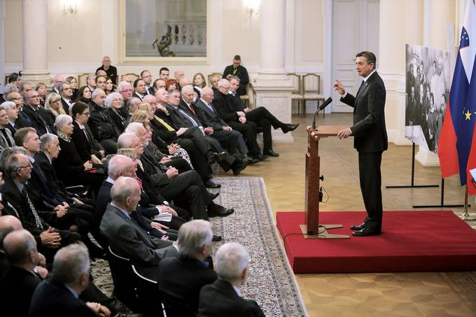 predsednik ob govorniškem pultu in sedeči gostje v veliki dvorani predsedniške palače