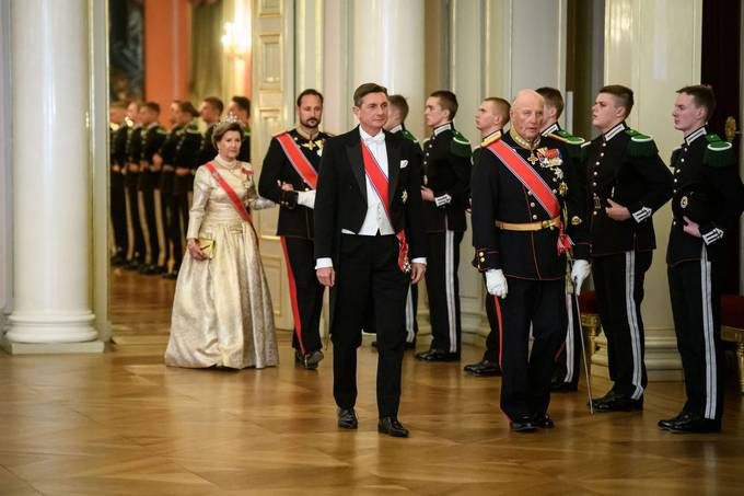 slovenski predsednik ob kralju, za njim norveška kraljica in princ, stopajo v dvorano mimo postrojenih vojakov
