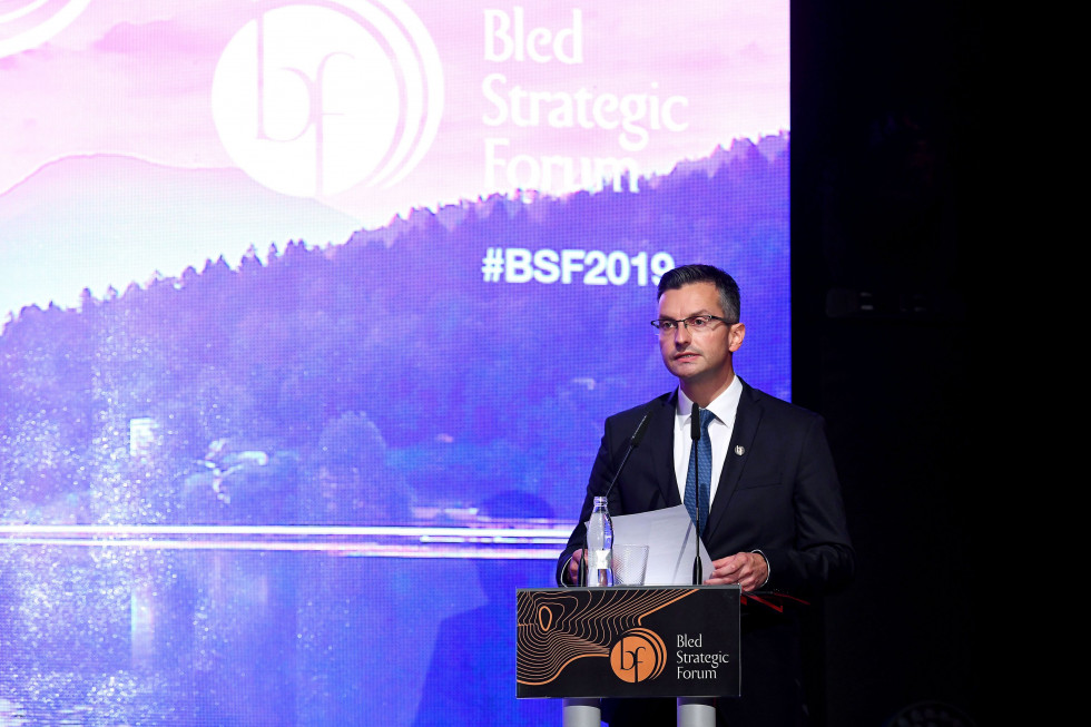 predsednik vlade ob govorniškem pultu v festivalni dvorani na Bledu