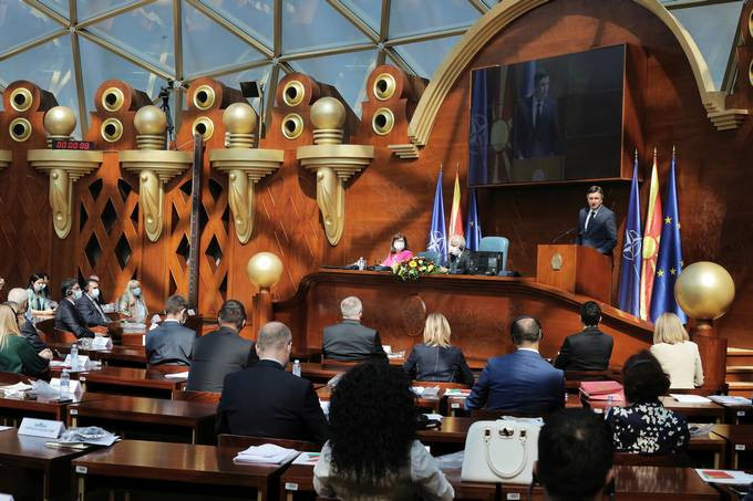 slovenski predsednik ob govorniškem pultu, sedeči poslanci in poslanke v dvorani makedonskega Sobranja
