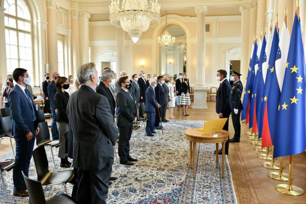 predsednike republike pred zastavami in stoječi gostje ob himni v veliki dvorani predsedniške palače