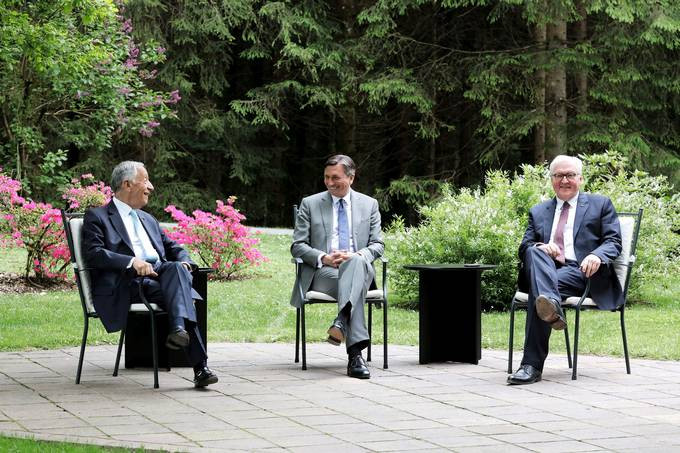 trije predsednike sedijo na foteljih, v ozadju posestvo Brdo