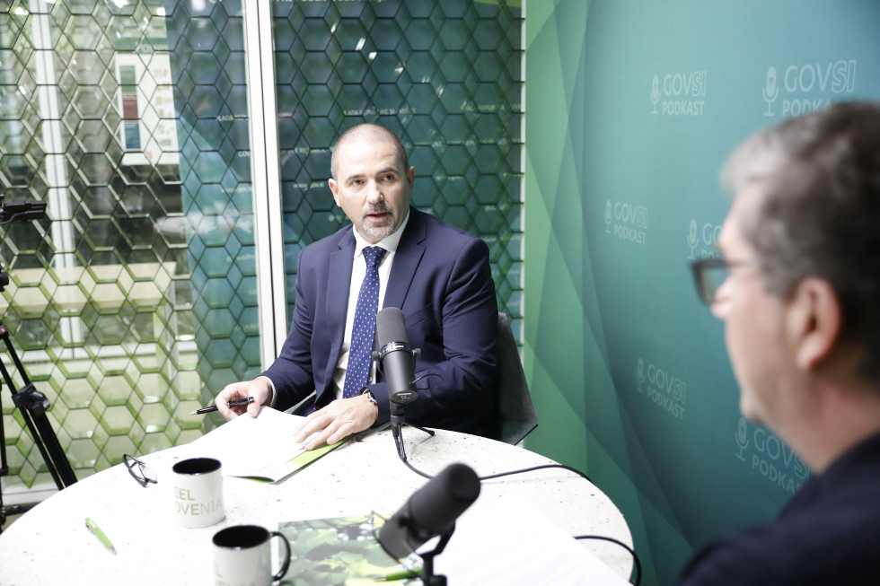 Boštjan Pavlin sedi za mizo, na kateri je mikrofon