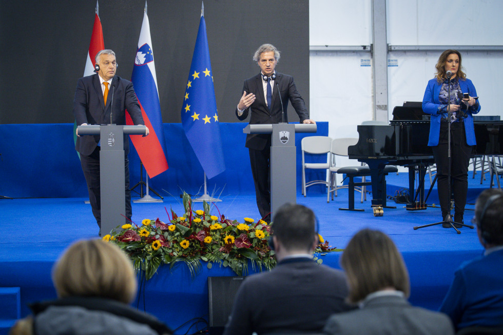 Viktor Orban in Rober Golob stojita na odru za govorniškima pultoma. Ob strani na odru stoji Petra Bezjak Cirman.
