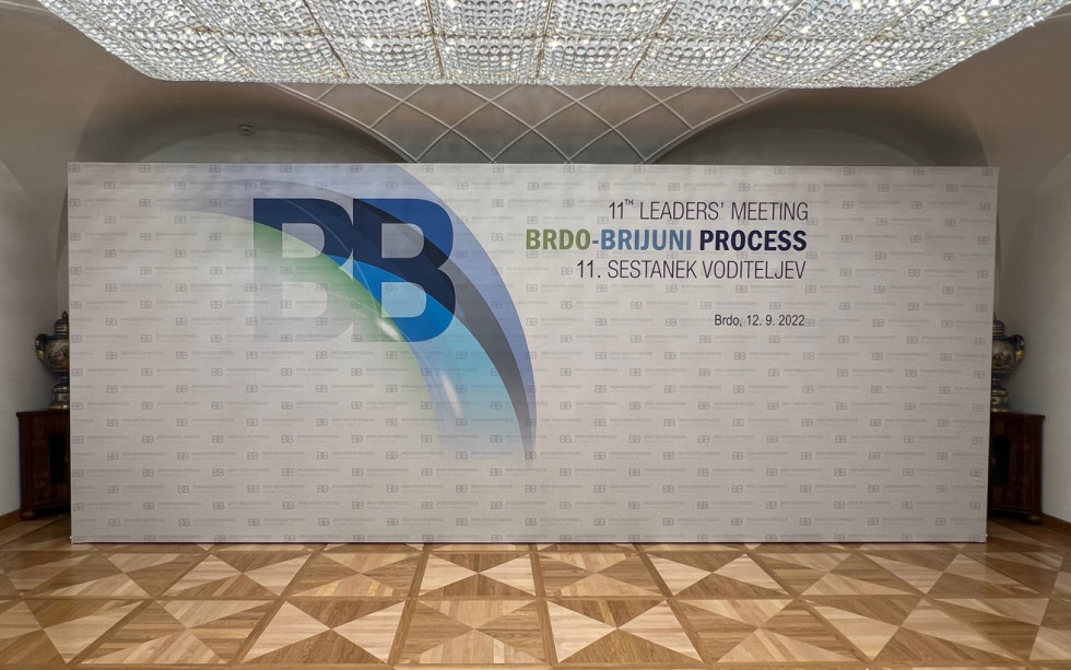 Ozadje Brdo-Brijuni Process z logotipom, postavljeno v dvorani.