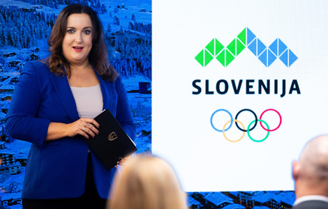 BP3 7283 (A speaker on stage with the Slovenian Olympic Committee logo in the background.)