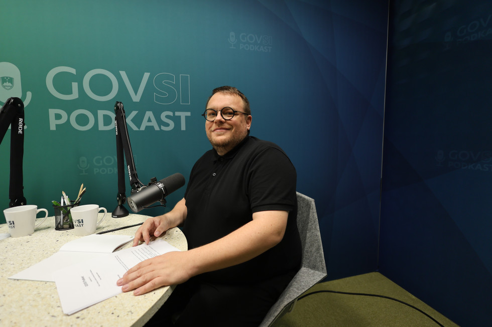 Minister sitting at a table with microphone on it