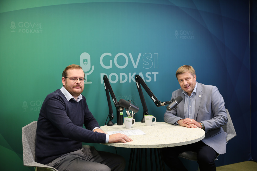 Dva moška sedita za okroglo mizo v studio, v ozadju napis GOVSI podkast.