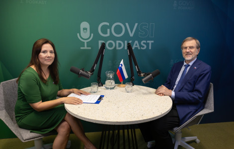 J57A0145 (A woman and a man are sitting at a round table with microphones, with a GOVSI podcast sign in the background.)