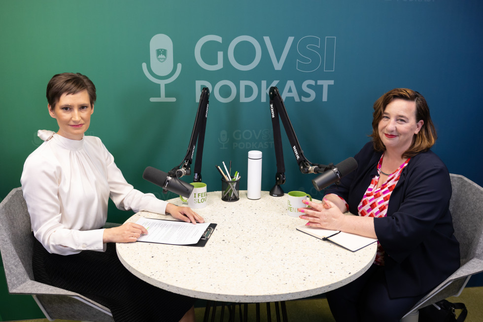 ženski sedita za okroglo mizo z mikrofoni, za njima napis govsi podkast