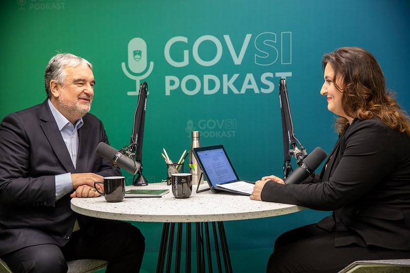 Emil Erjavec and Petra Bezjak Cirman sitting at a round table, behind them is a sign GOVSI podkast.