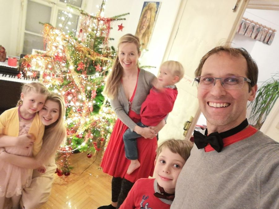 Novoletni selfi družine: oče, mama, štirje otroci, v ozadju novoletna jelka.