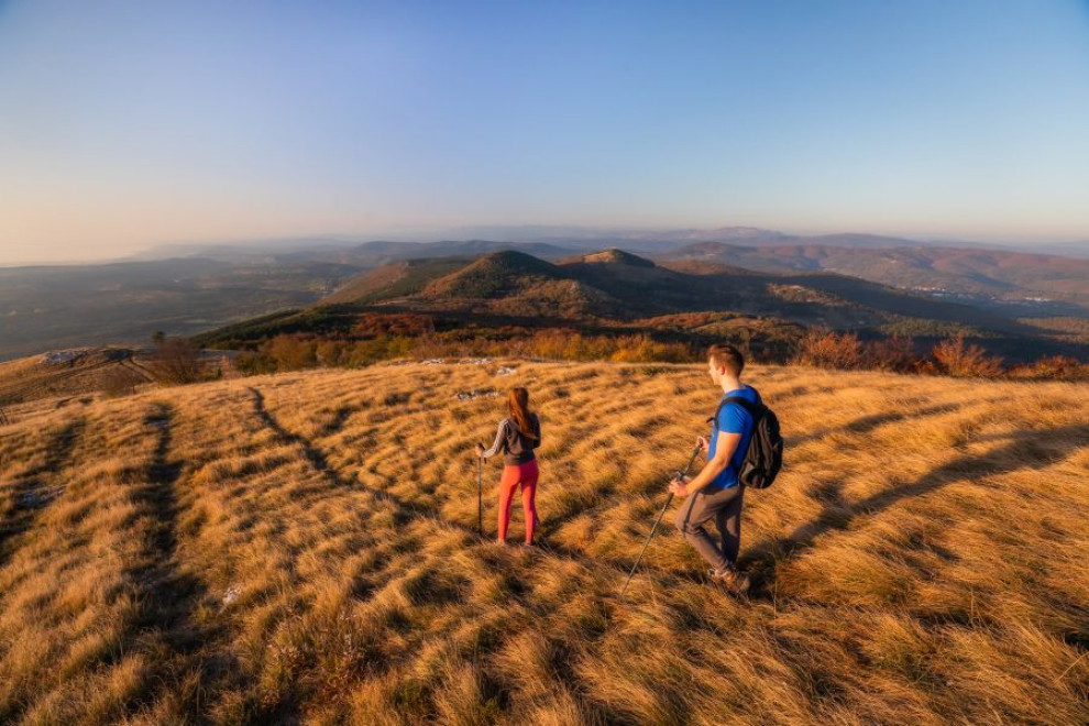 Fant in dekle hodita po hribu, razgled na hribe in gore.