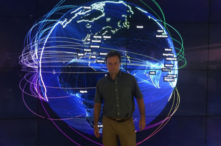 Marko Grobelnik stands, behind a digitized representation of the world.