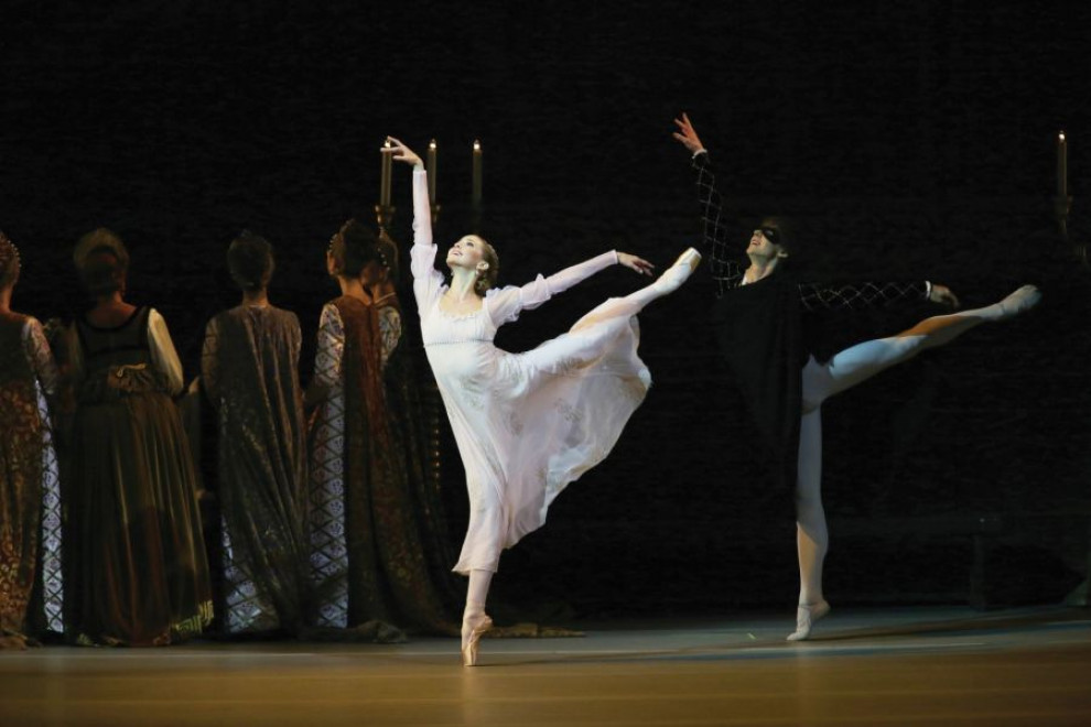 The ballerina and ballet dancer perform on stage.
